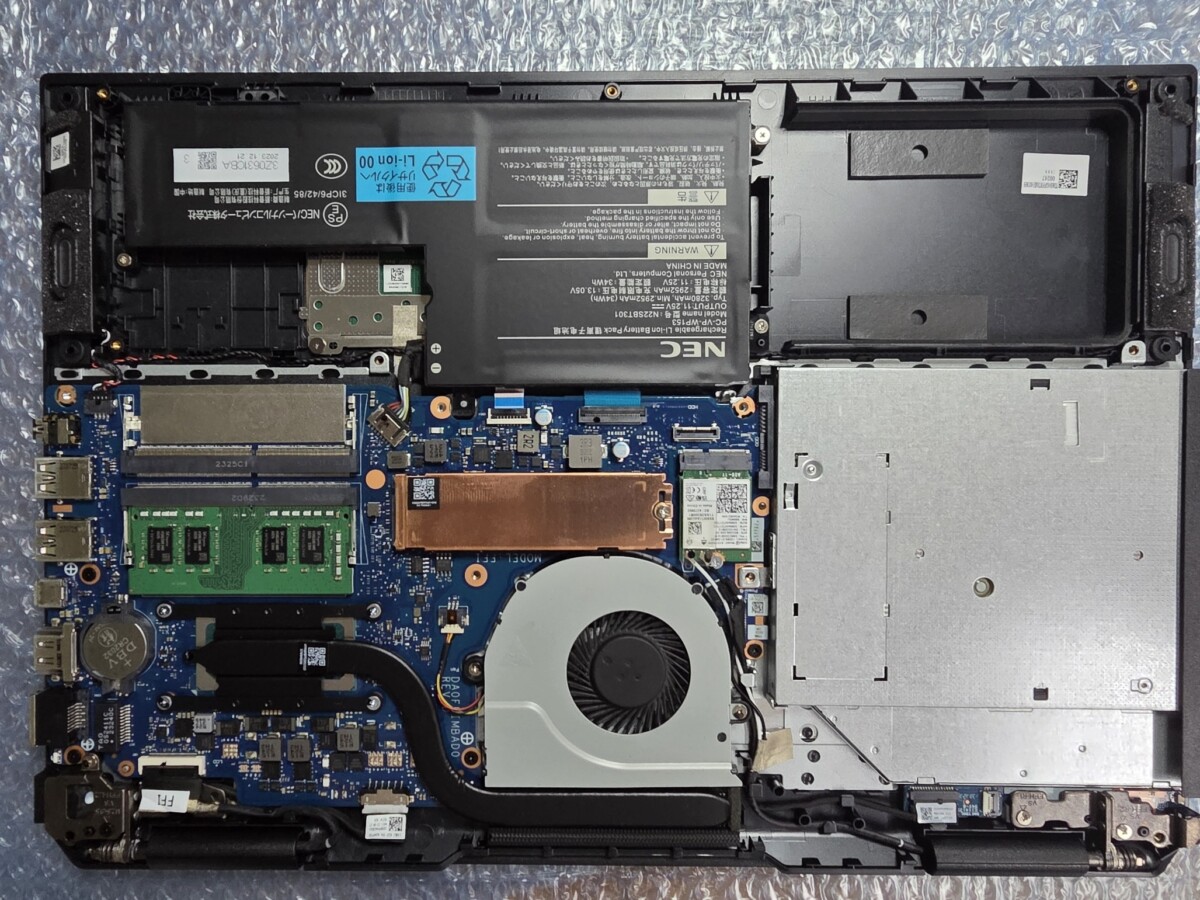 バッテリーを本体へ装着し、外装カバーを元通りにしようとしている様子